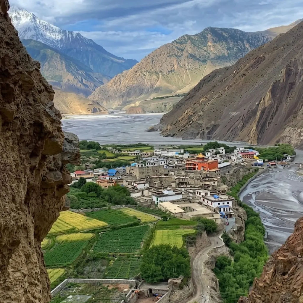 Stone houses and green agricultural fields of Kagbeni village beside the Kali Gandaki riverbed in Mustang.