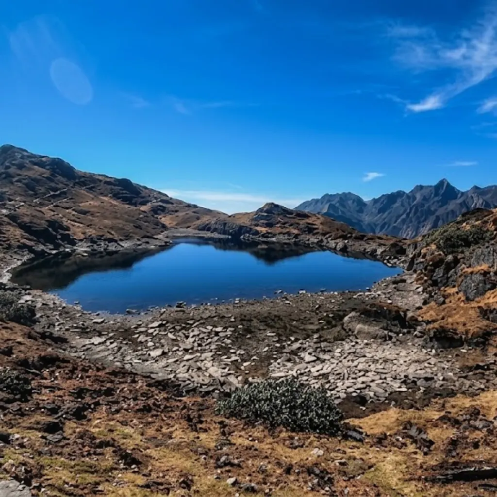 Pristine deep blue high-altitude glacial lake surrounded by rugged boulder fields and barren mountain terrain in Makalu Barun.
