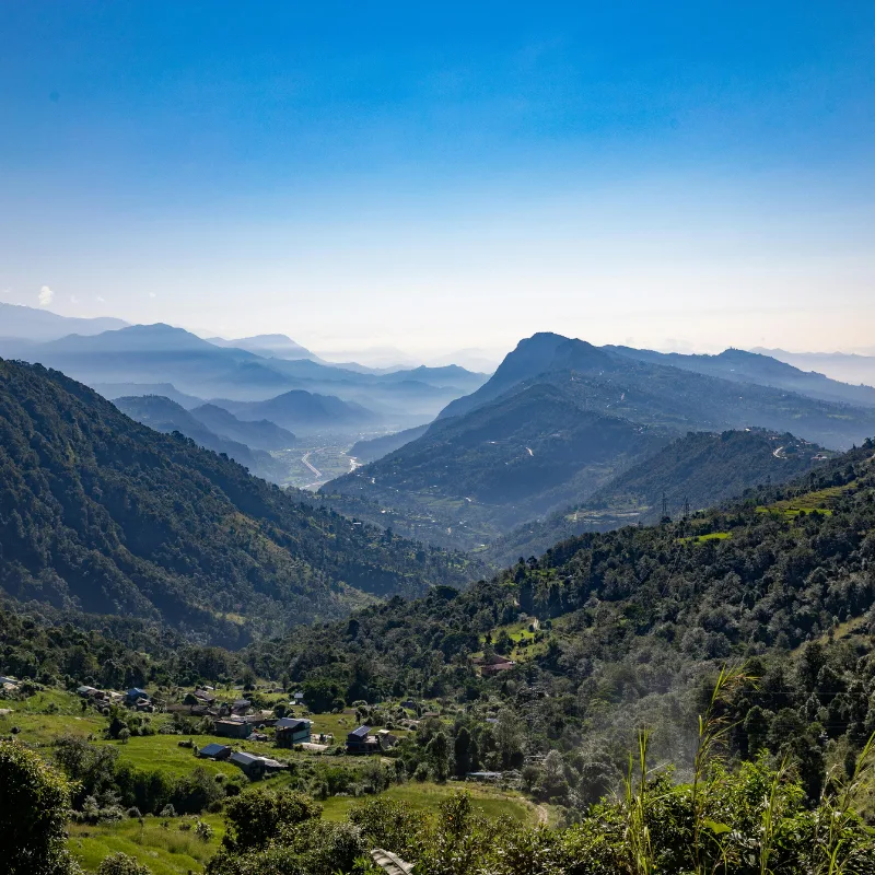 Lush green mountain valley with traditional Nepali villages and terraced hillsides along the Annapurna trekking route.